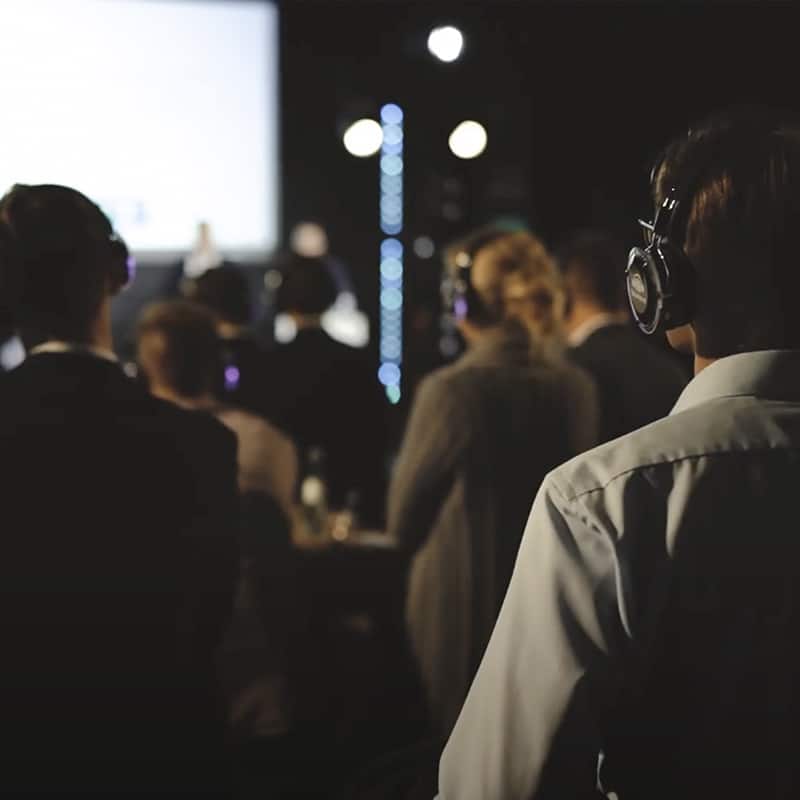 Attendees with headphones at a Compleo conference on the future of mobility.