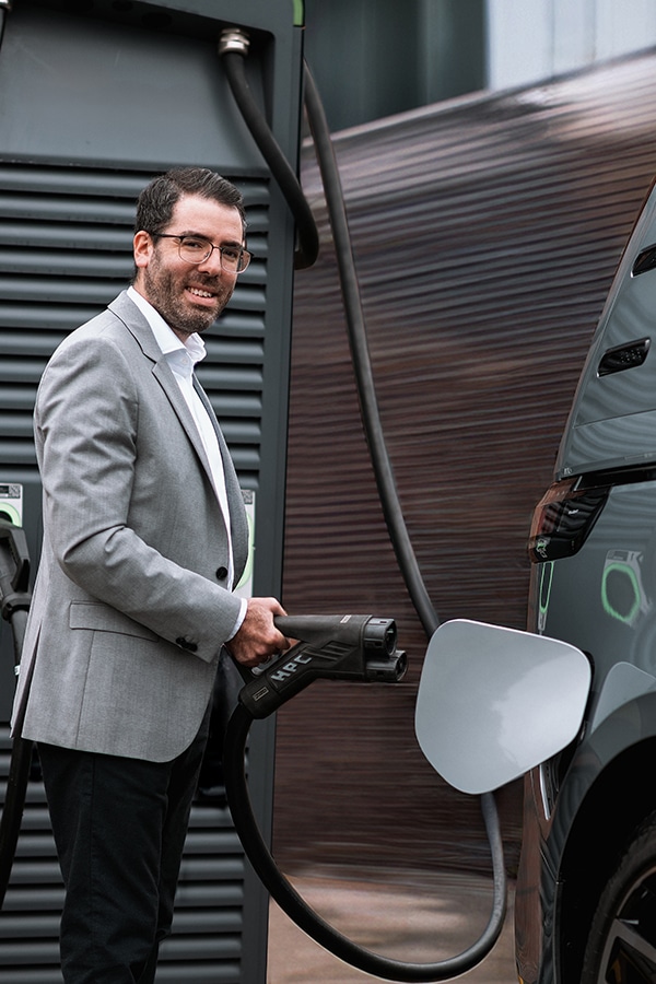 Mann lädt Elektrofahrzeug auf und repräsentiert damit die Zukunft der Mobilität mit EV-Lade-Technologie.
