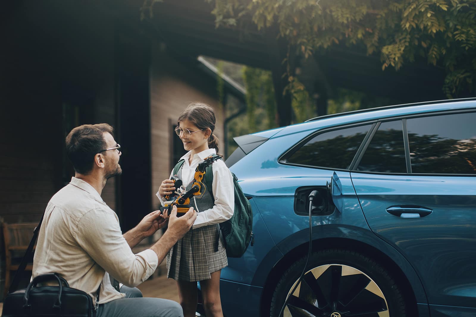 Father and daughter beside an EV charging car, symbolizing the future of mobility and sustainable eMobility solutions.